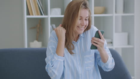 Portrait-of-happy-business-woman-enjoy-success-on-mobile-phone-at-home-office.-Closeup-joyful-girl-reading-good-news-on-phone-in-slow-motion.-Surprised-lady-celebrating-victory-on-phone-in-apartment.
